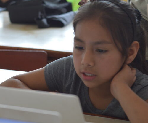 Young girl coding on a laptop, social justice