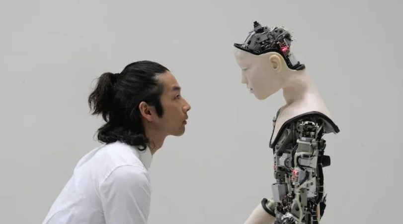 Asian man looking at a robot, Byte