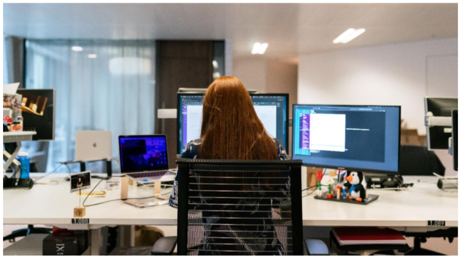 Woman working at multiple screens