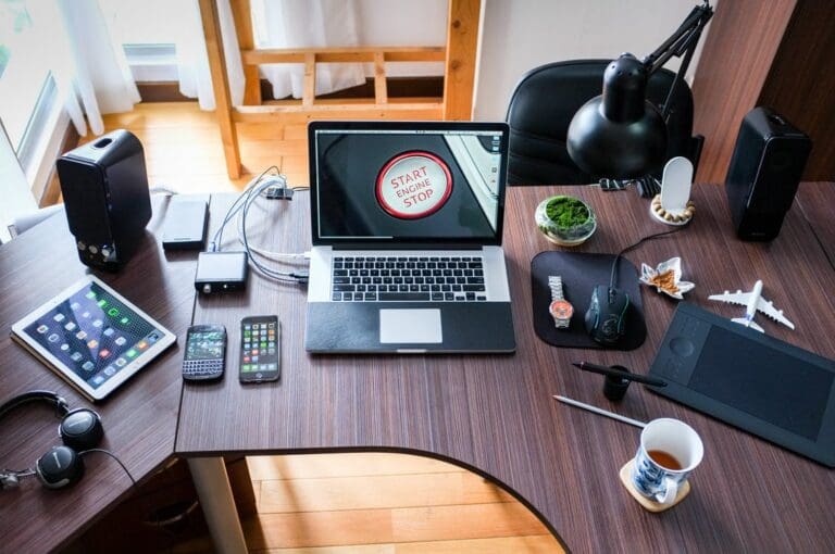 Birds eye image of a desk with a laptop , tablet, phone and other technology devices, tech industry