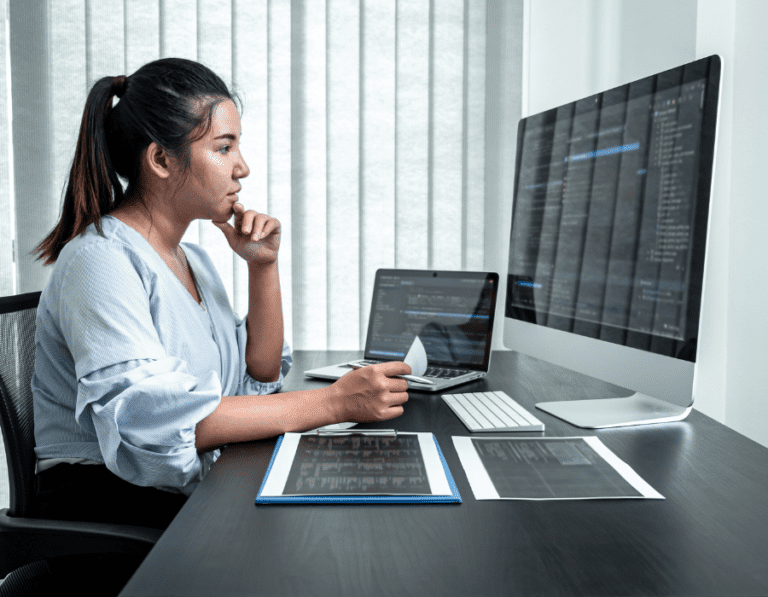 Female DevOps Engineer looking at computer screen in an office
