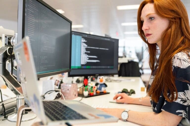 Female software engineer working on coding on a computer in the office