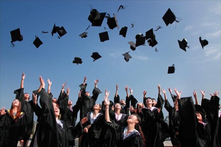 Newly Graduated People Wearing Black Academy Gowns throwing Hats Up in the Air, Computing Degrees