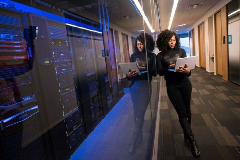 Black woman with laptop in server room