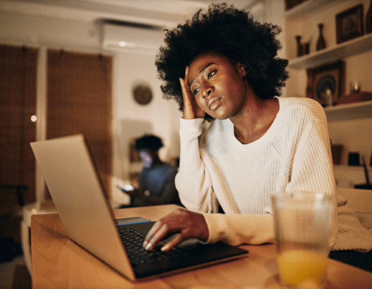 Unhappy woman working on a laptop, Blue Monday concept