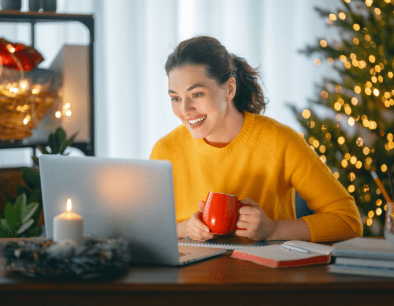 Woman wearing an orange jumper working on her career plan from home with her Christmas decorations