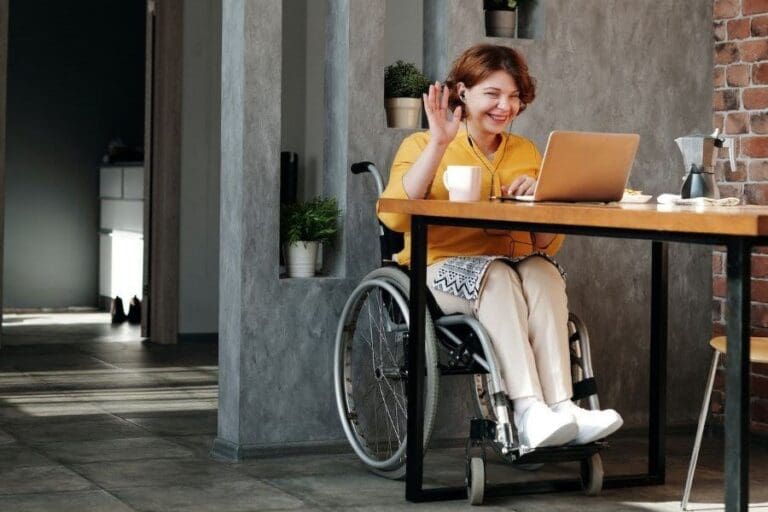 Woman in wheelchair working remotely at laptop.