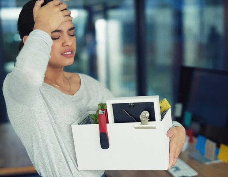 Woman being laid off with her box of possessions