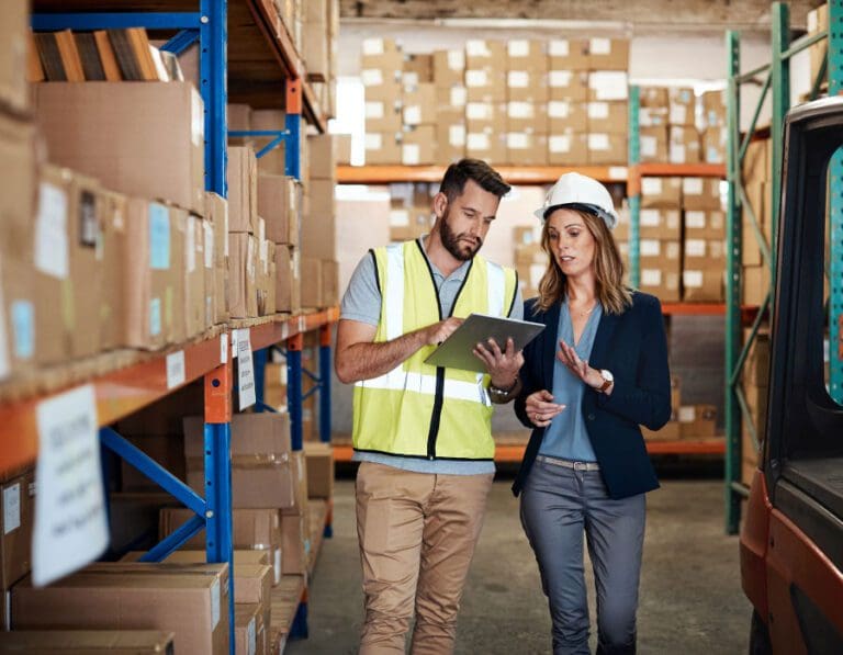 Woman discusses logistics plan with colleague in a warehouse