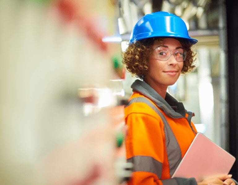 Female engineering wearing a hi-vis jacket and a blue hard hat