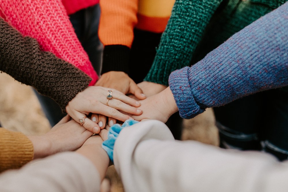 Handing joined at the centre of a circle of people