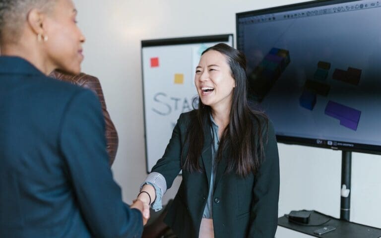 Asian woman shaking hands with investor, tech startup funding concept