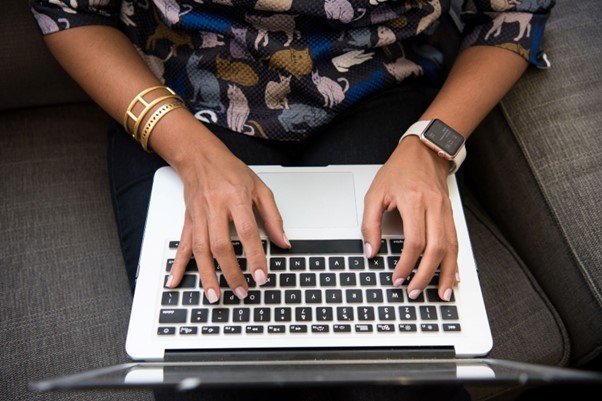 Woman with hands poised over laptop keyboard