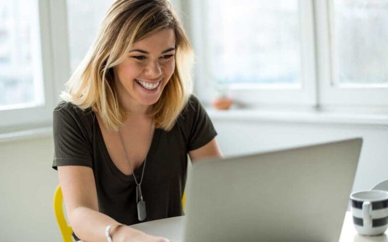 Smiling woman looking at a laptop at work