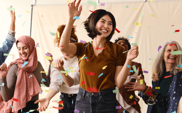 Diverse women in tech jumping up and down with confetti falling around them