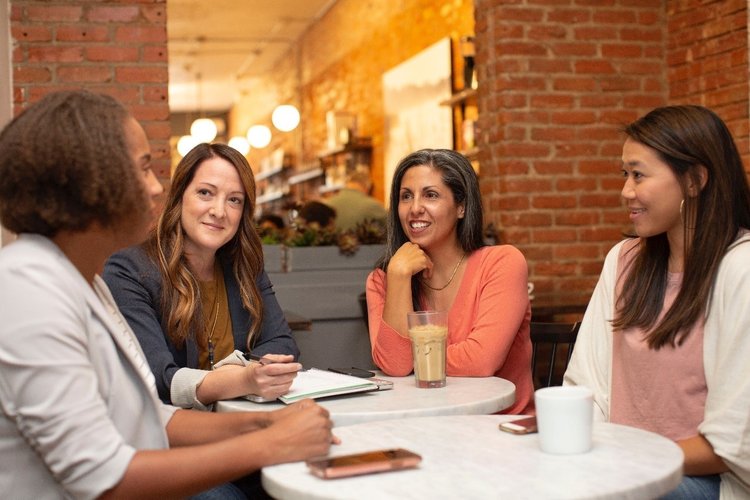 Group of women discussing tech in a cafe