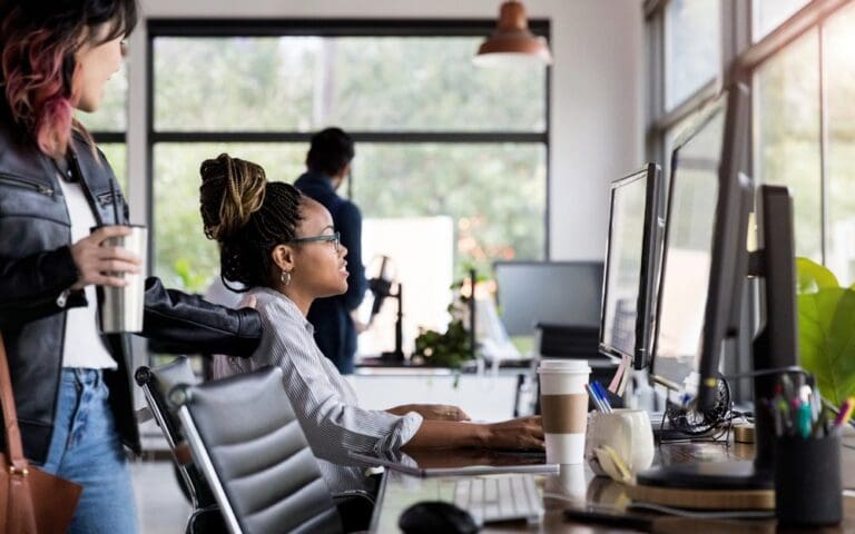 Women working in office in front of computer screen