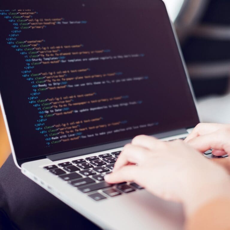 Woman's hands coding HTML on a laptop screen