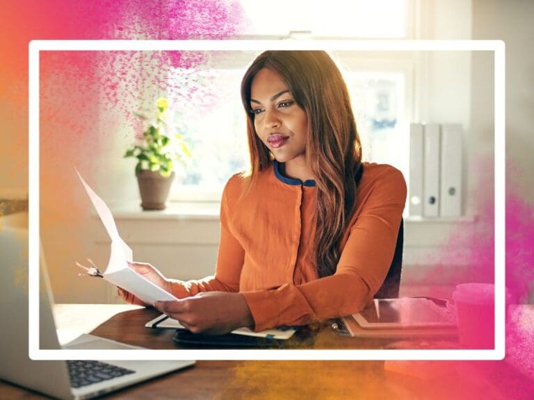 Young Black female tech entrepreneur sitting at a desk looking at a laptop