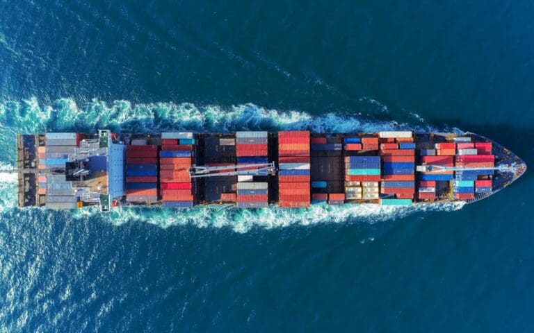 Aerial view Top speed with beautiful wave of container ship full load container with crane loading container for logistics import export or transportation concept background, product manager in the shipping industry