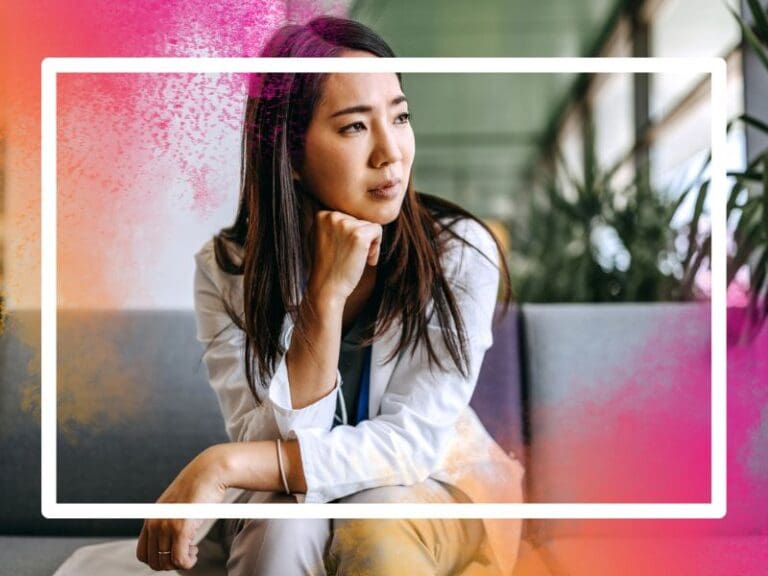 Asian woman with brown hair, wearing a grey suit looking worried, imposter syndrome concept