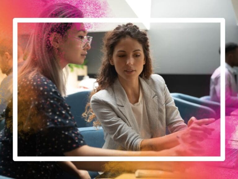 Female mentor instructing trainee in a computer project, mentoring for women in tech concept