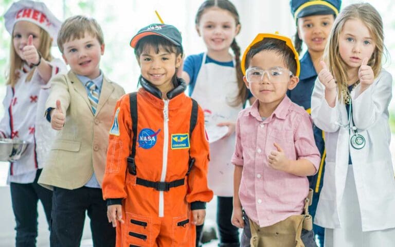 A multi-ethnic group of children at kindergarten dressed in STEM career related outfits