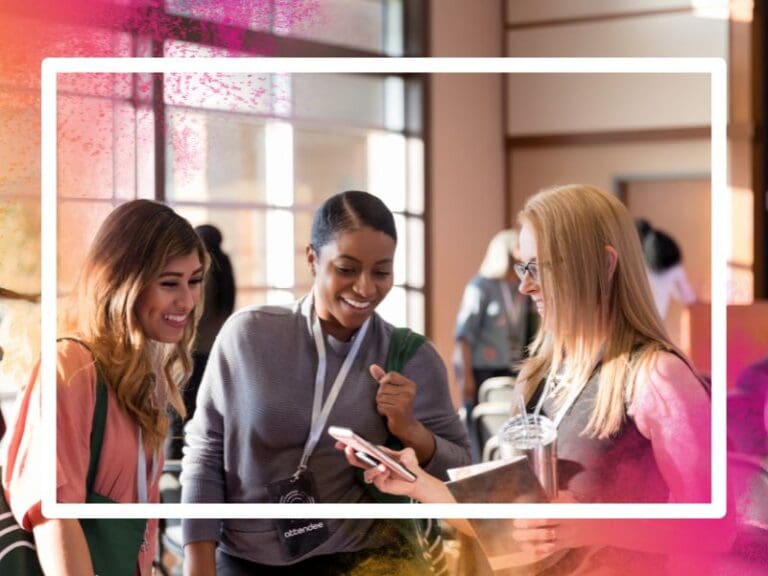 Diverse women attending expo smile at smart phone photos, women in tech networking