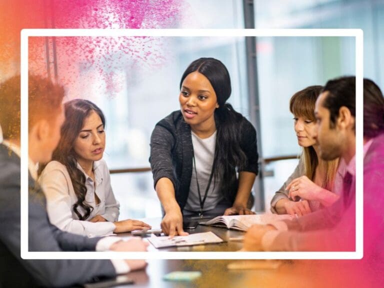 A black female leader pointing to a document on a desk, surrounded by her colleagues, female leadership concept