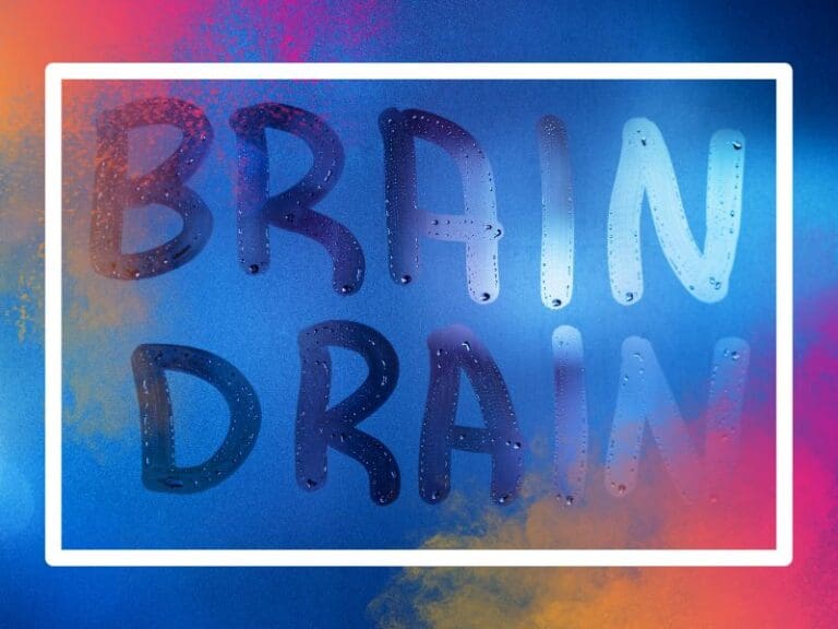 the words brain drain written on night wet window glass close-up with blurred background in classic blue color