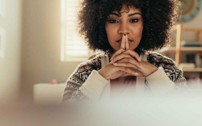 Thoughtful woman at her desk, menopause concept