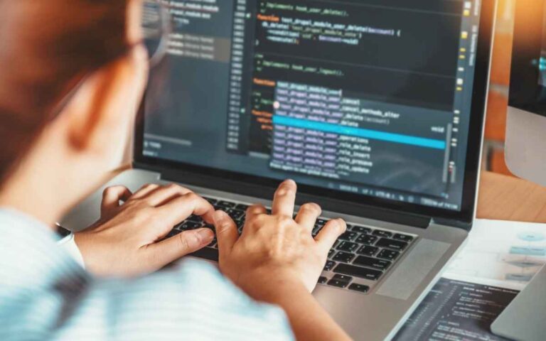 POV of a female coder inputting coding language on a laptop