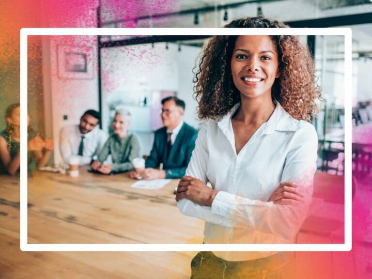 Photo of an African-American businesswoman with her arms crossed standing in front of her team, female leadership concept
