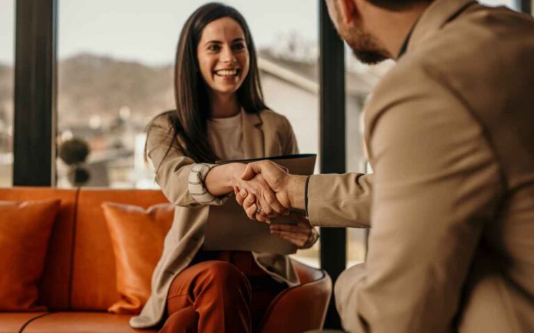 Young businessman shaking hands with a female job candidate, transitioning into tech concept