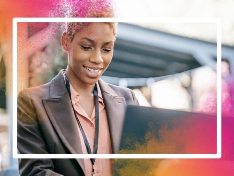 Smiling black woman using laptop for searching information, tech roles concept