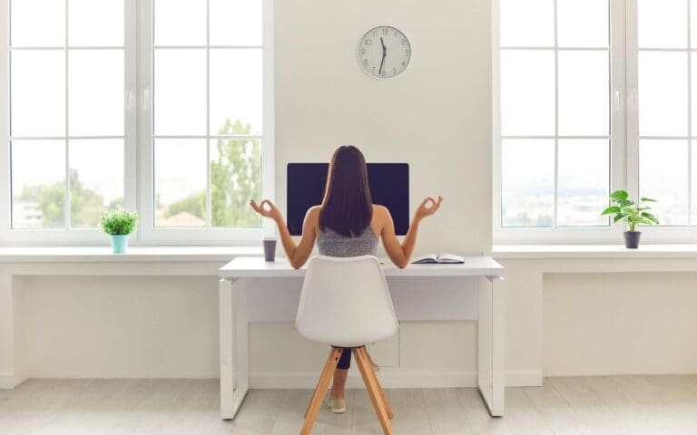 Woman Taking Break from Work and Meditating Sitting at Office Table with Computer and Coffee, Well-being concept