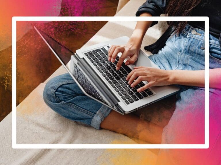 Looking down on a young woman with curly hair typing on a laptop, tech skills concept