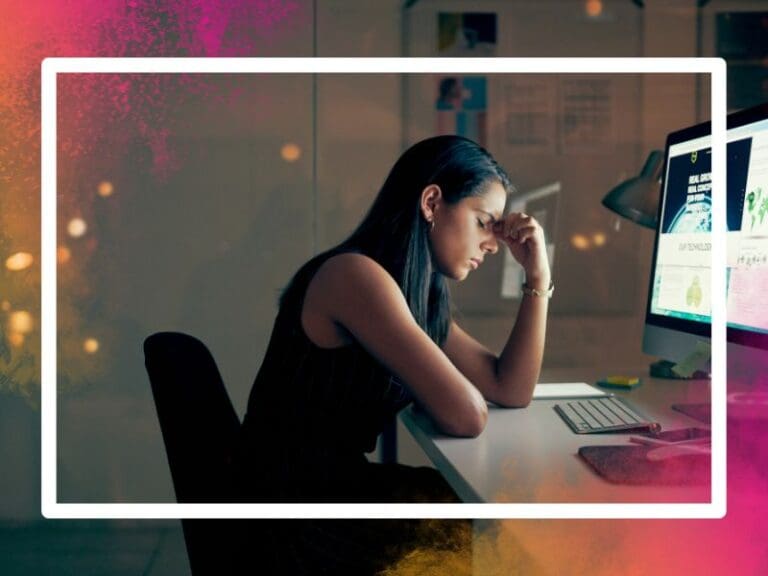 Burnout woman sitting at her desk with her head in her hands, reskilling concept