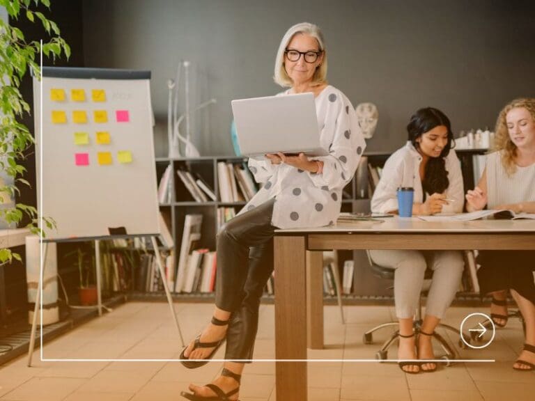 A Woman Sitting on the Table While Holding a Laptop, career development concept