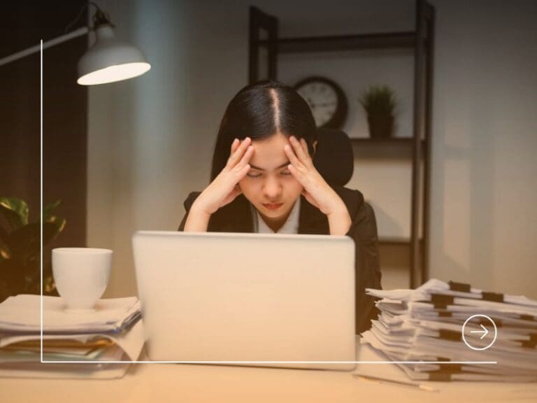 Stressed asian business woman working late at night in the office hands on head feeling headache. Tired woman looking at laptop working hard sitting in the dark room office. Overtime concept