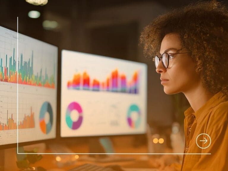 Data analyst examining graphs and charts on dual monitors