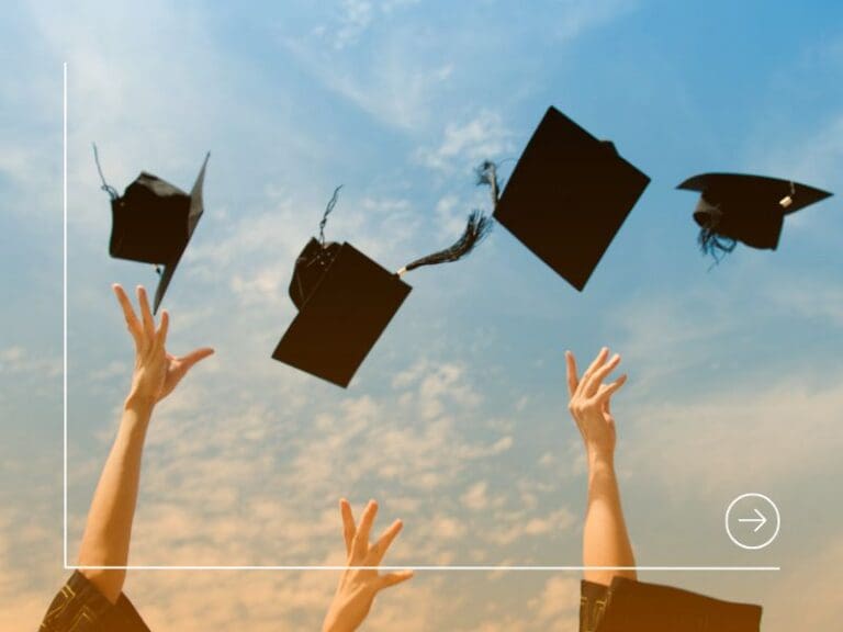 Graduation caps being thrown into the air by graduates